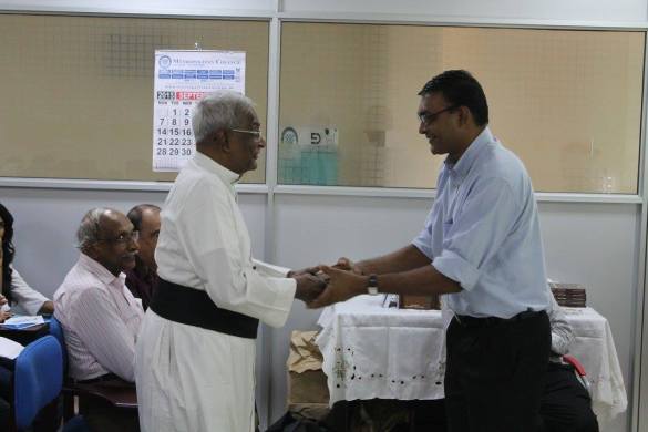 Ravindra Ranasinha giving a copy of his book to Fr Mervyn Fernando